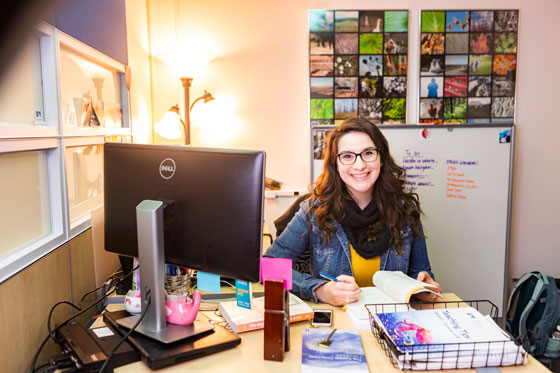 Faith Fleagle, eCampus career coach, smiling at her desk.