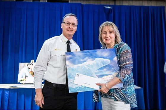 Kim Runnion receiving a picture of a polar bear for her 25 years of service.